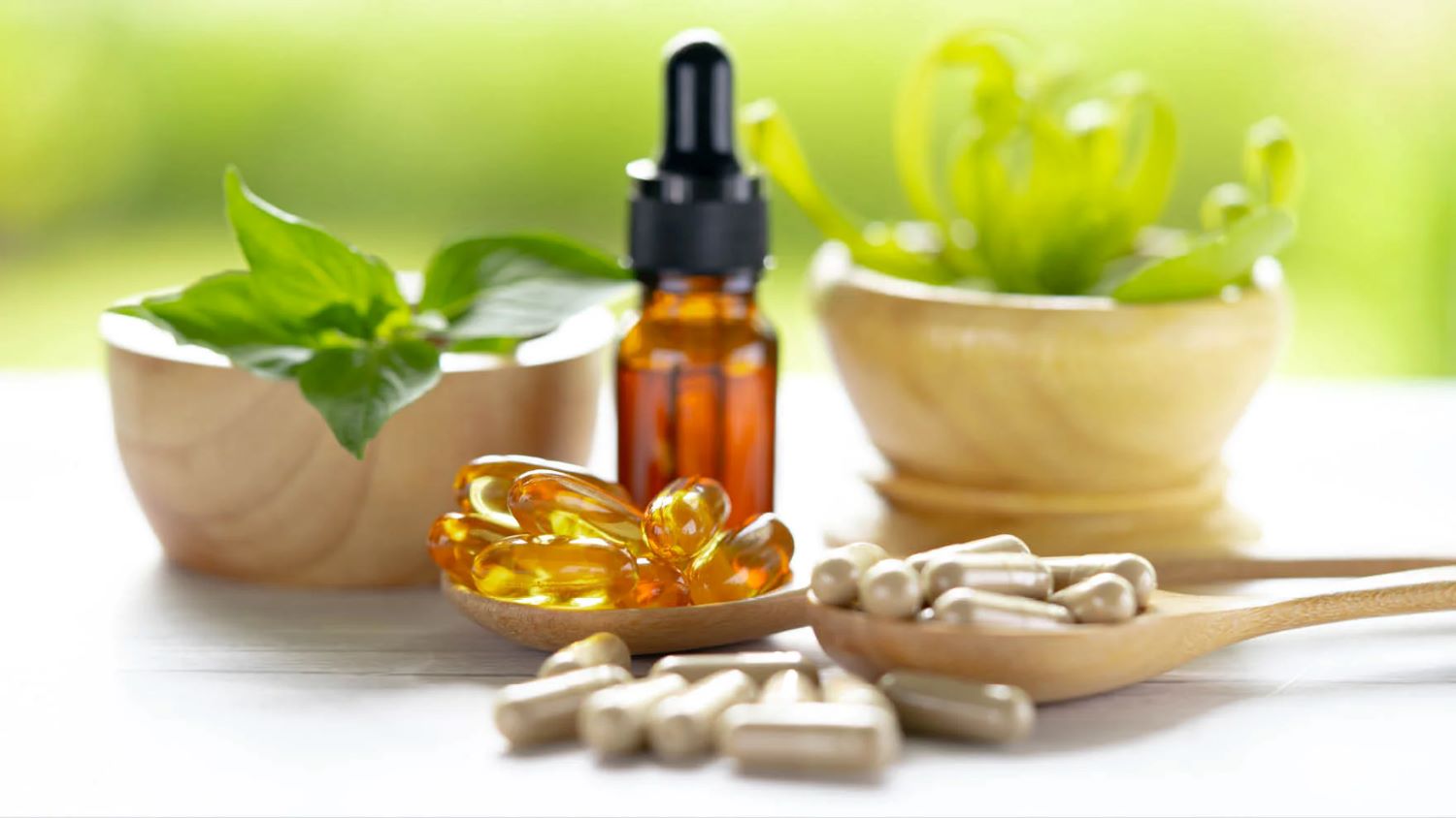 Varie pillole su un tavolo, circondate da erbe medicinali.